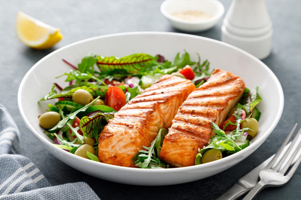 Heart healthy plate of food with fresh salmon and greens