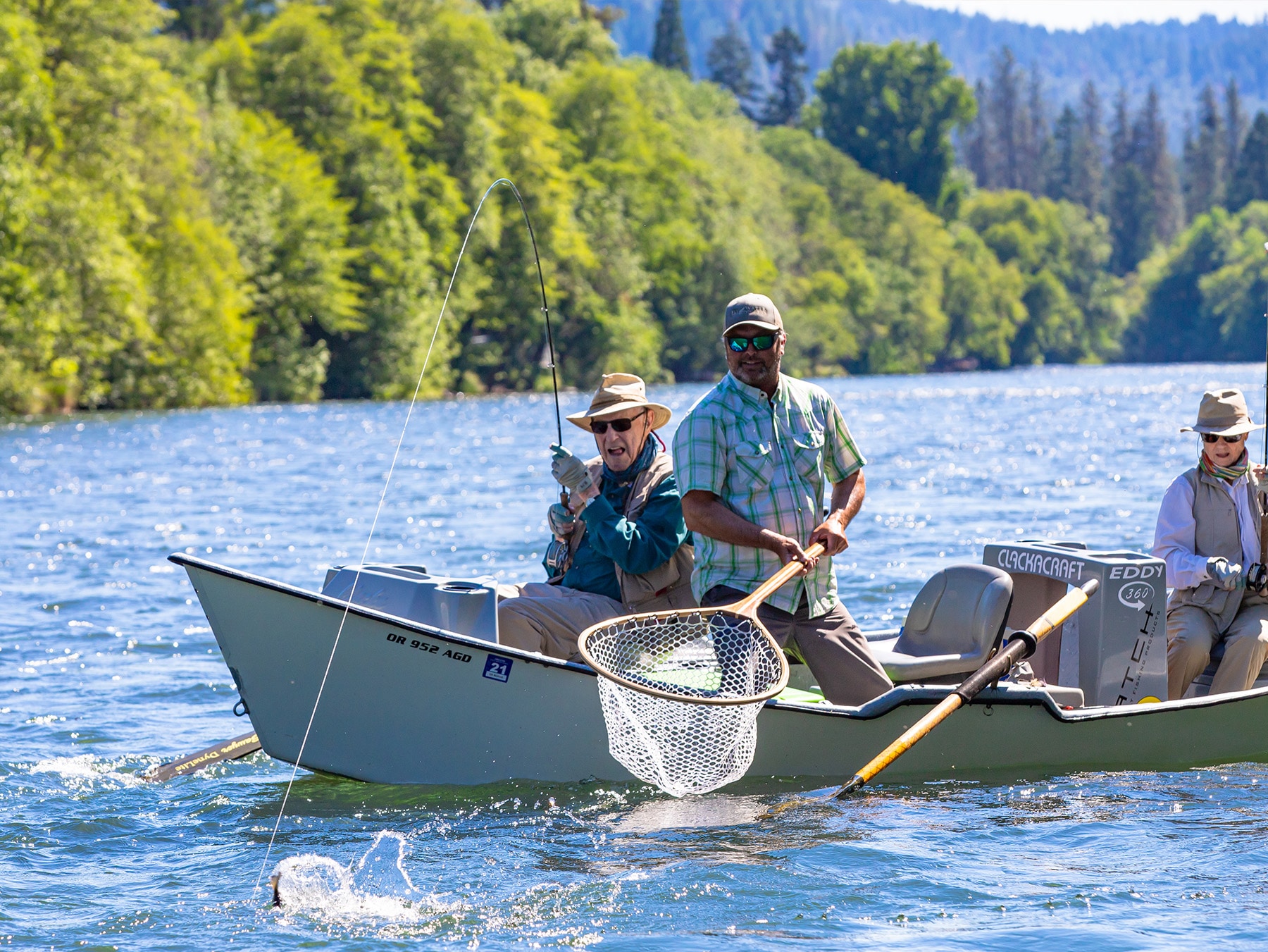 Ross and Susie Miles fly fishing on a drift boat with a guide.